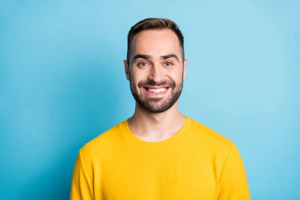 Photo portrait of smiling cheerful man wearing yellow sweatshirt isolated on bright blue color background — 图库照片