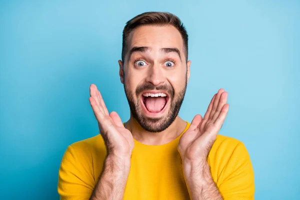 Foto de joven loco emocionado feliz sonriente hombre alegre en camiseta amarilla ver gran venta aislado sobre fondo de color azul — Foto de Stock