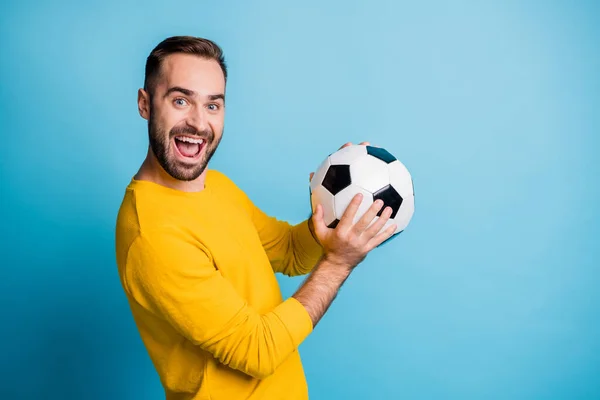 Фотопортрет человека с мячом улыбается смеясь в желтой одежде изолированы на ярком синем фоне цвета — стоковое фото