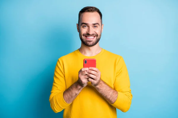 Foto portret van vrolijke student houden mobiele telefoon geïsoleerd op levendige blauwe kleur achtergrond — Stockfoto