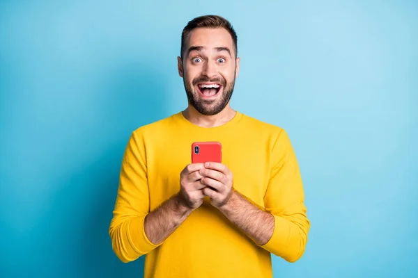 Foto ritratto di studente sorpreso fissando smartphone tenuta bocca aperta isolato su vibrante sfondo di colore blu — Foto Stock