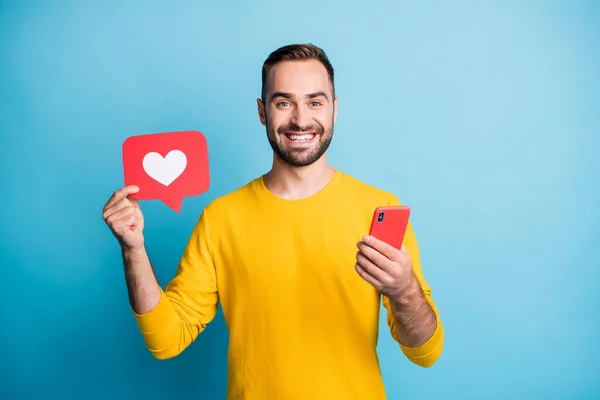 Foto portret van student tonen hart pictogram social media feedback houden mobiele telefoon geïsoleerd op levendige blauwe kleur achtergrond — Stockfoto