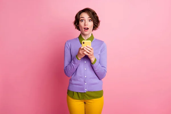 Foto de senhora engraçada segurar telefone ler comentários positivos usar calças jumper roxo isolado cor rosa fundo — Fotografia de Stock
