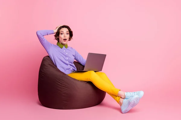 Volledig lichaam profiel zijkant foto gefrustreerd meisje zitten boon stoel werk laptop dragen broek geïsoleerde pastel kleur achtergrond — Stockfoto