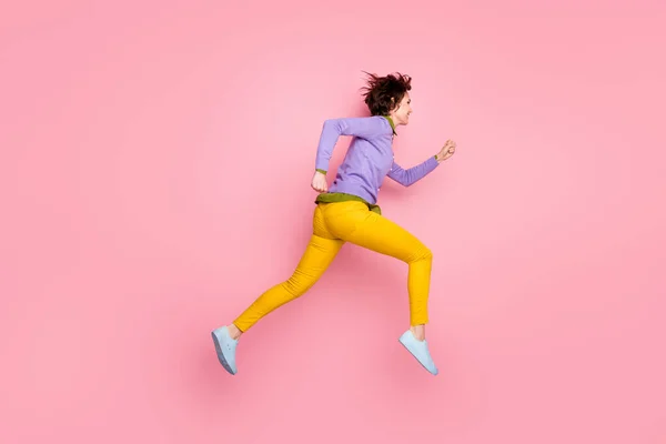 Full längd profil sida foto av flicka hoppa köra snabba rabatter bära violett gummiskor isolerad rosa färg bakgrund — Stockfoto