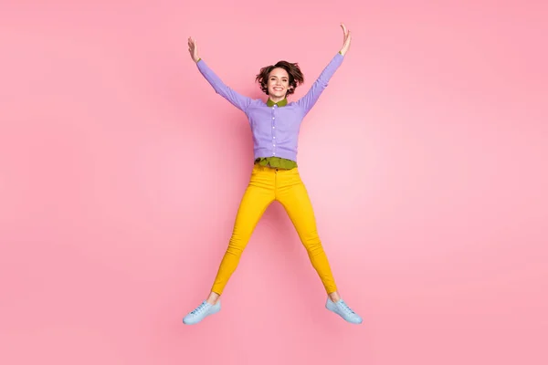 Foto de longitud completa de niña infantil descuidado salto levantar las manos aisladas sobre fondo de color pastel —  Fotos de Stock