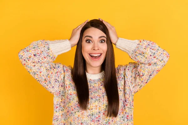 Foto de mujer encantadora joven asombrada cogida de la mano venta de noticias cabeza aislada sobre fondo de color amarillo — Foto de Stock