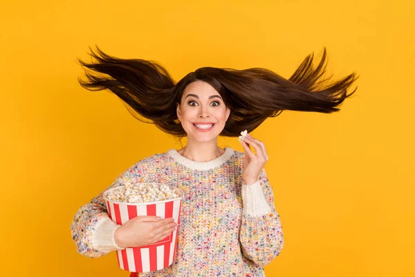 Photo of crazy excited happy young lady fly hair watch film eat pop corn isolated on shine yellow color background