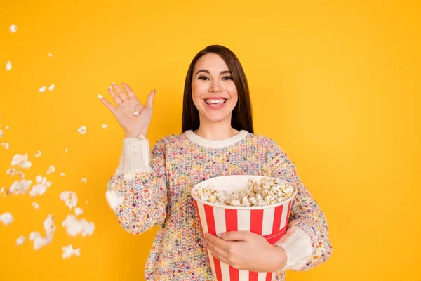 Photo of happy cheerful young woman throw popcorn hold bucket watch tv isolated on yellow color background — Stock Photo, Image