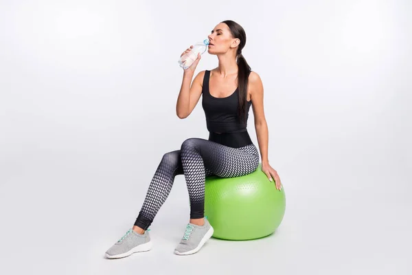 Pleine longueur photo de charmante belle jeune femme boire pause eau sit green fitball isolé sur fond de couleur grise — Photo