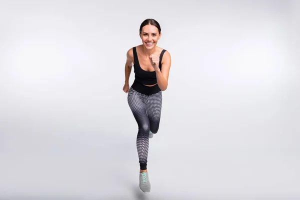 Foto de larga duración de la cola de caballo morena pelo joven sonrisa buen humor saltar correr aislado sobre fondo de color gris —  Fotos de Stock