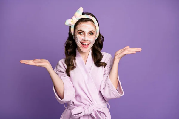 Foto ritratto di ragazza che indossa accappatoio mantenendo spazi blandi a confronto con maschera in bagno isolato vibrante colore viola sfondo — Foto Stock