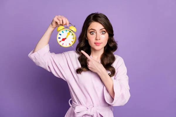 Foto de chica joven uso ojo punto de parche dedos reloj alarma tiempo cosmetología procedimiento aislado sobre fondo de color violeta —  Fotos de Stock