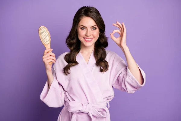 Foto de jovem mulher segurar escova mostrar okey escolha sinal escolher recomendar terapia cabelo promo isolado sobre fundo cor violeta — Fotografia de Stock