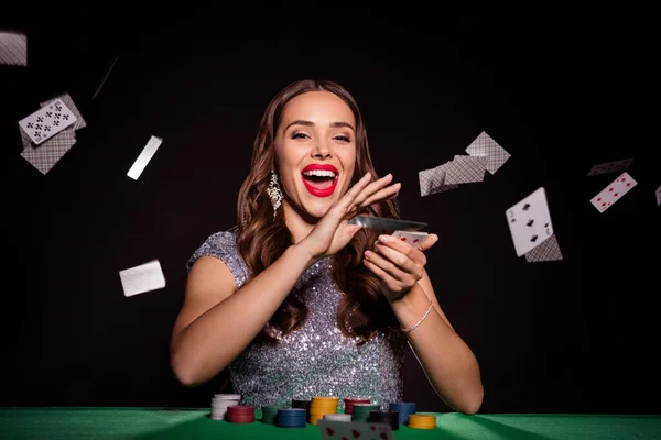 Photo of crazy lady siedzieć poker stół rzucać karty otwarte usta nosić błyszczącą sukienkę odizolowany czarny kolor tła — Zdjęcie stockowe