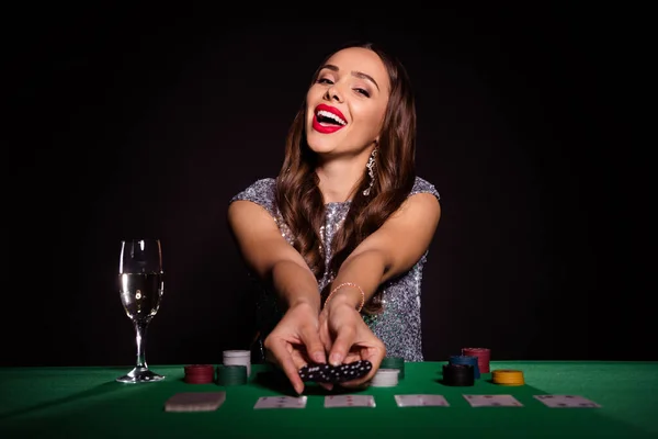 Photo of wesoły pozytywny lady siedzieć poker tabeli posiadają wiele żetonów nosić błyszczące kolczyki sukienka odizolowany czarny kolor tła — Zdjęcie stockowe