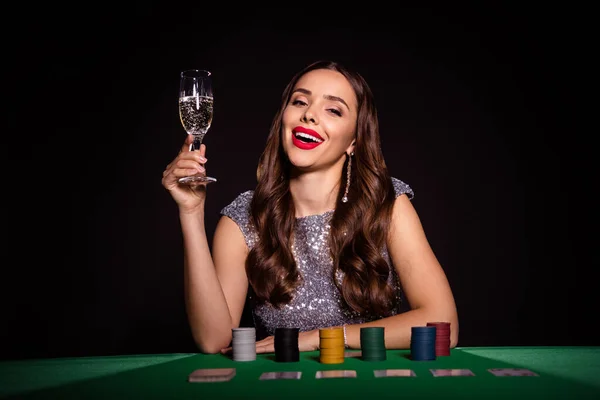 Foto de senhora sentar mesa de poker segurar vinho beber champanhe vestir vestido lustroso isolado cor preta fundo — Fotografia de Stock