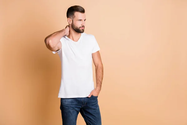 Foto de homem bonito jovem confiante mão séria no bolso olhar espaço vazio isolado sobre fundo cor bege — Fotografia de Stock