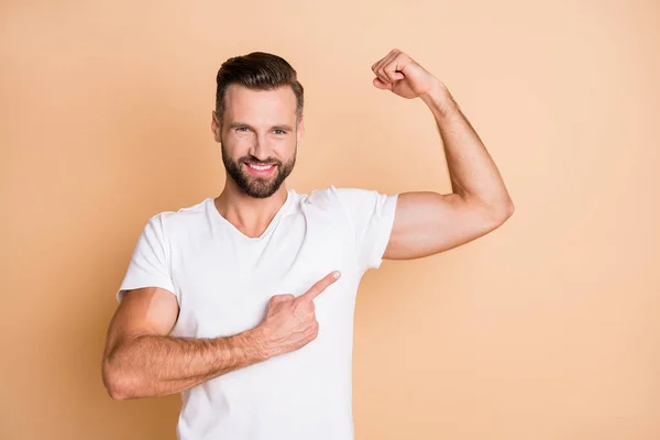 Photo of young handsome sportsman happy positive smile point finger biceps advert choice isolated over beige color background — Stock Photo, Image
