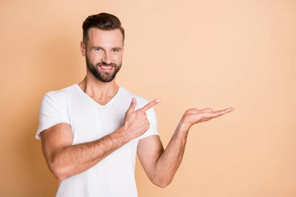 Foto de chico joven feliz sonrisa positiva dedo dedo vacío espacio promo oferta sugieren producto aislado sobre fondo de color beige — Foto de Stock