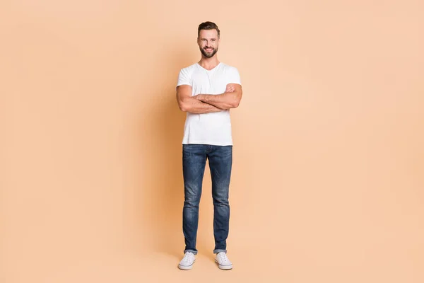 Foto de comprimento total de homem bonito jovem feliz sorriso positivo confiante cruzado mãos isoladas sobre fundo de cor bege — Fotografia de Stock