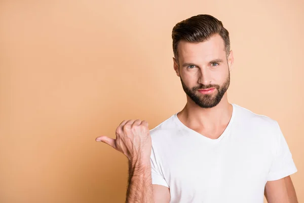 Foto de hombre guapo joven mostrar punto pulgar espacio vacío promo anuncio opción recomendar aislado sobre fondo de color beige — Foto de Stock