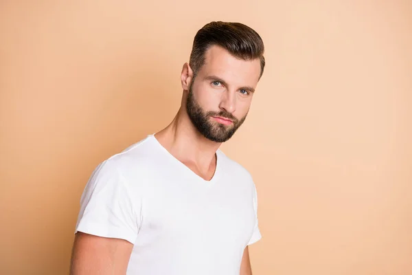 Zdjęcie młody przystojny zarost człowiek poważne pewność nosić biały t-shirt izolowane na beżowym tle kolor — Zdjęcie stockowe