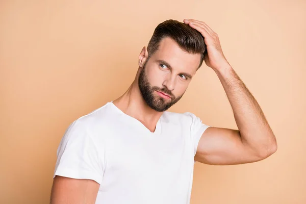 Foto van jonge knappe man genieten haarverzorging lotion hairdo kijken lege ruimte geïsoleerd over beige kleur achtergrond — Stockfoto