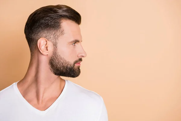 Foto del lado del perfil del joven hombre cerda guapo mirada confiada espacio vacío aislado sobre fondo de color beige — Foto de Stock