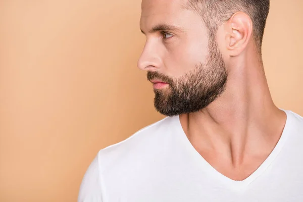 Foto lateral do perfil cortado do jovem homem de restolho bonito olhar sério espaço vazio isolado sobre fundo de cor bege — Fotografia de Stock