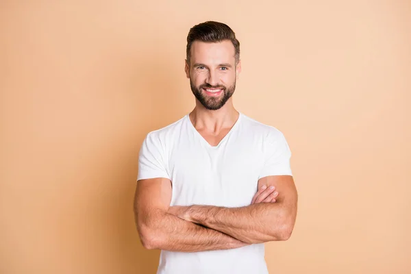 Foto de joven guapo hombre feliz sonrisa positiva confianza cruzada manos aisladas sobre fondo de color beige — Foto de Stock