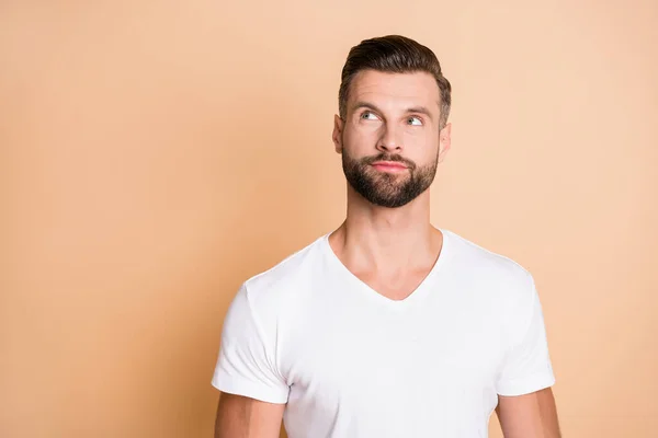 Foto do jovem homem cerda bonito feliz olhar curioso espaço vazio isolado sobre fundo cor bege — Fotografia de Stock