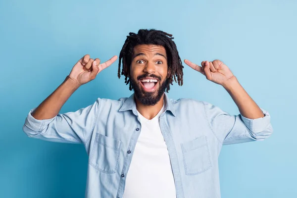 Portrait d'un beau mec joyeux portant une chemise en jean démontrant une nouvelle coupe de cheveux isolée sur fond de couleur bleu vif — Photo