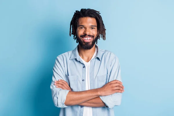 Portret van leuke vrolijke content guy dragen jeans shirt kleding gevouwen armen geïsoleerd over helder blauwe kleur achtergrond — Stockfoto