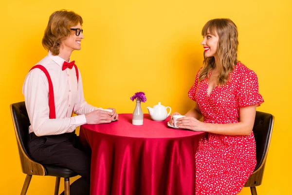 Fénykép portré szép pár ül az étteremben beszél ivás tea elszigetelt élénk sárga színű háttér — Stock Fotó