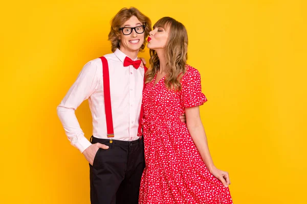 Foto retrato de encantadora menina beijando namorado na data isolada no fundo amarelo vibrante — Fotografia de Stock