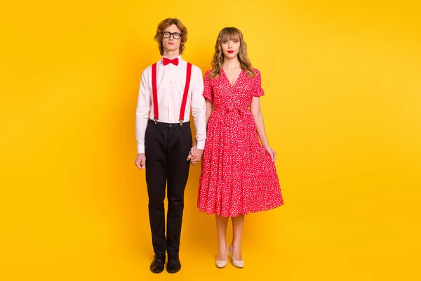 Tamanho total do corpo foto de casal mantendo as mãos olhando sério na data roupas festivas isoladas no fundo de cor amarelo brilhante — Fotografia de Stock