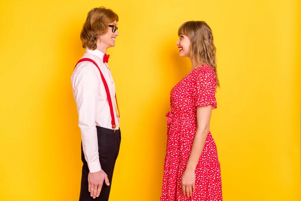 Foto retrato de pareja alegre mirándose el día de San Valentín sonriendo feliz aislado sobre fondo amarillo vibrante — Foto de Stock