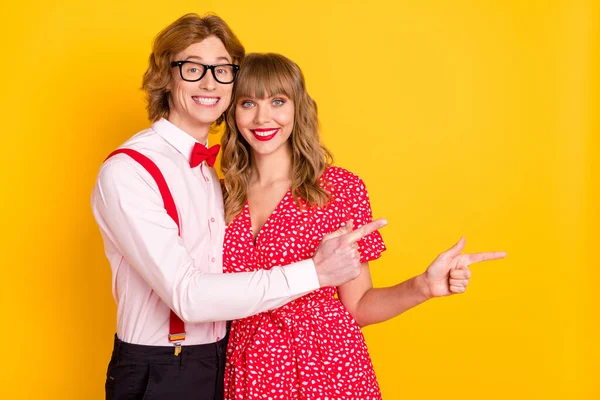 一对可爱的夫妇在明亮的黄色背景下展示空白广告的照片肖像 — 图库照片