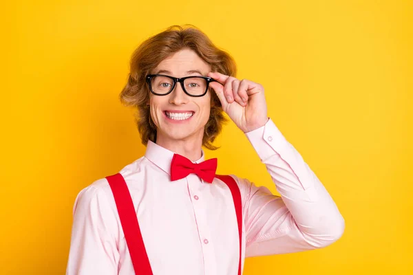 Foto retrato de un tipo con el pelo rojo sonriendo en tirantes de camisa gafas aislado sobre un fondo amarillo vibrante — Foto de Stock