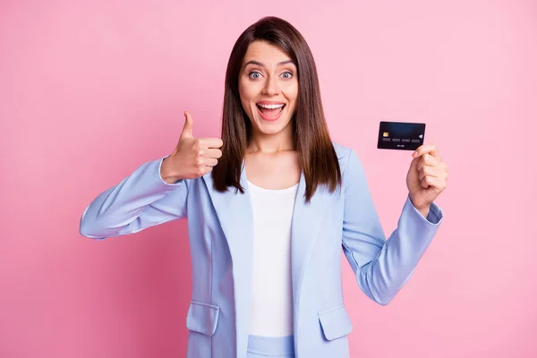 Photo de jeune femme d'affaires positive souriante attrayante et joyeuse montrer pouce vers le haut tenir carte de crédit isolé sur fond de couleur rose — Photo