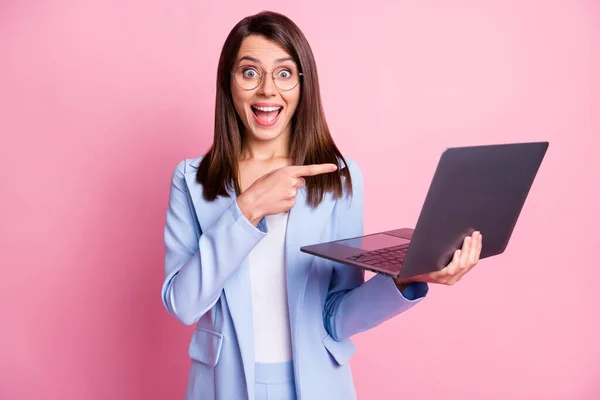 Zdjęcie młodej dziewczyny podekscytowany szczęśliwy uśmiech wskazać palec laptop reklama promo wybrać nosić garnitur odizolowany ponad różowy kolor tła — Zdjęcie stockowe