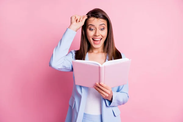 Fénykép fiatal nő csodálkozott izgatott meglepett hírek boldog mosoly olvasni könyv kéz touch szemüveg elszigetelt rózsaszín szín háttér — Stock Fotó