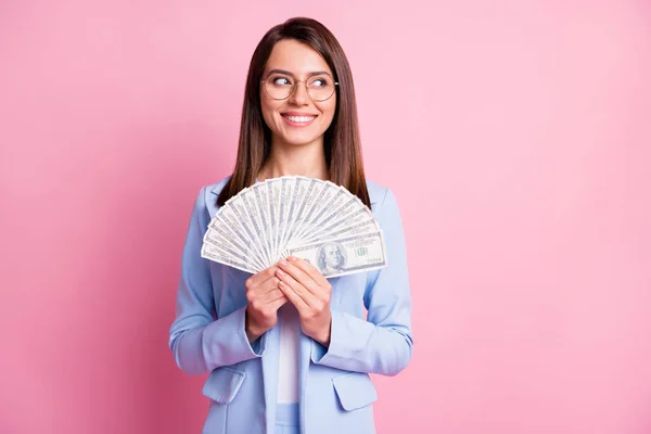 Foto ritratto di donna guardando lo spazio vuoto tenendo ventilatore in contanti isolato su sfondo rosa pastello — Foto Stock