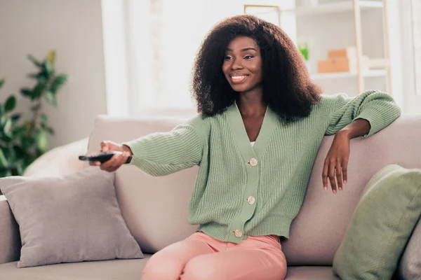 Foto de joven alegre afro mujer feliz sonrisa positiva canal interruptor ver película descanso fin de semana sentarse sofá en casa — Foto de Stock