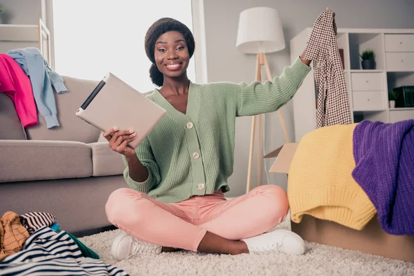 Cuerpo completo tamaño foto chica sentada en el suelo con la tableta la venta de cosas en internet sonriendo — Foto de Stock