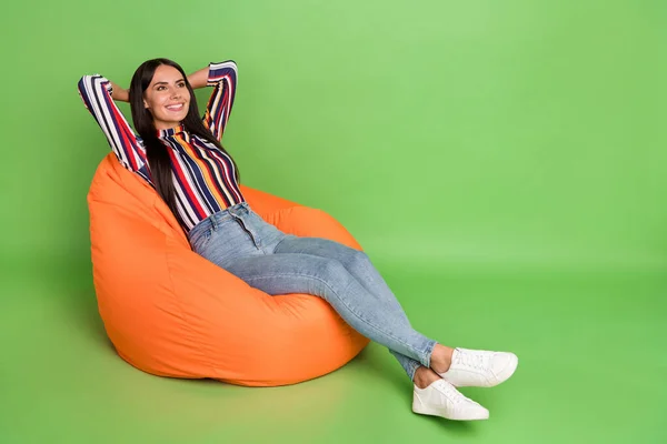 Portret atrakcyjnej wesołej dziewczyny leżącej w miękkim torbie na krześle odpoczynku czas wolny odizolowany nad zielonym pastelowym tle koloru — Zdjęcie stockowe