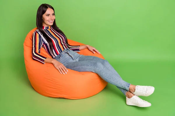Portret atrakcyjnej wesołej dziewczyny siedzącej na krześle worek odpoczynku wolny czas odizolowany na jasnozielonym tle koloru — Zdjęcie stockowe