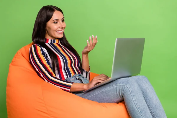 Profil sisi tampilan potret menarik gadis ceria duduk di kursi menggunakan laptop konferensi berbicara terisolasi di atas warna hijau cerah latar belakang — Stok Foto