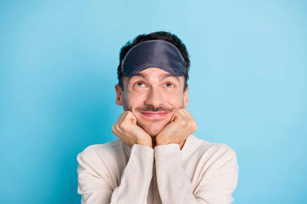 Retrato de agradable divertido animado tipo morena con máscara de sueño mirando hacia arriba fantaseando aislado sobre fondo de color azul brillante —  Fotos de Stock